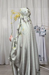 La tenue de prière femme SAKINA portée en vert chartreuse révèle la texture du tissu Armani Silk et la douceur des broderies.